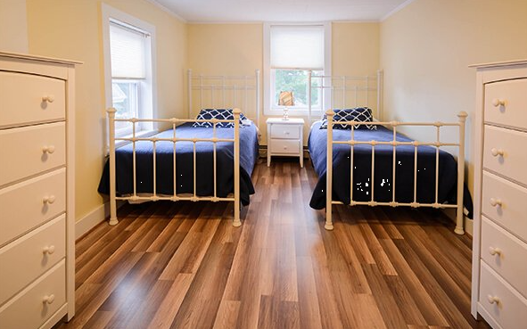 Twin beds with blue bedding in a bright shared room
