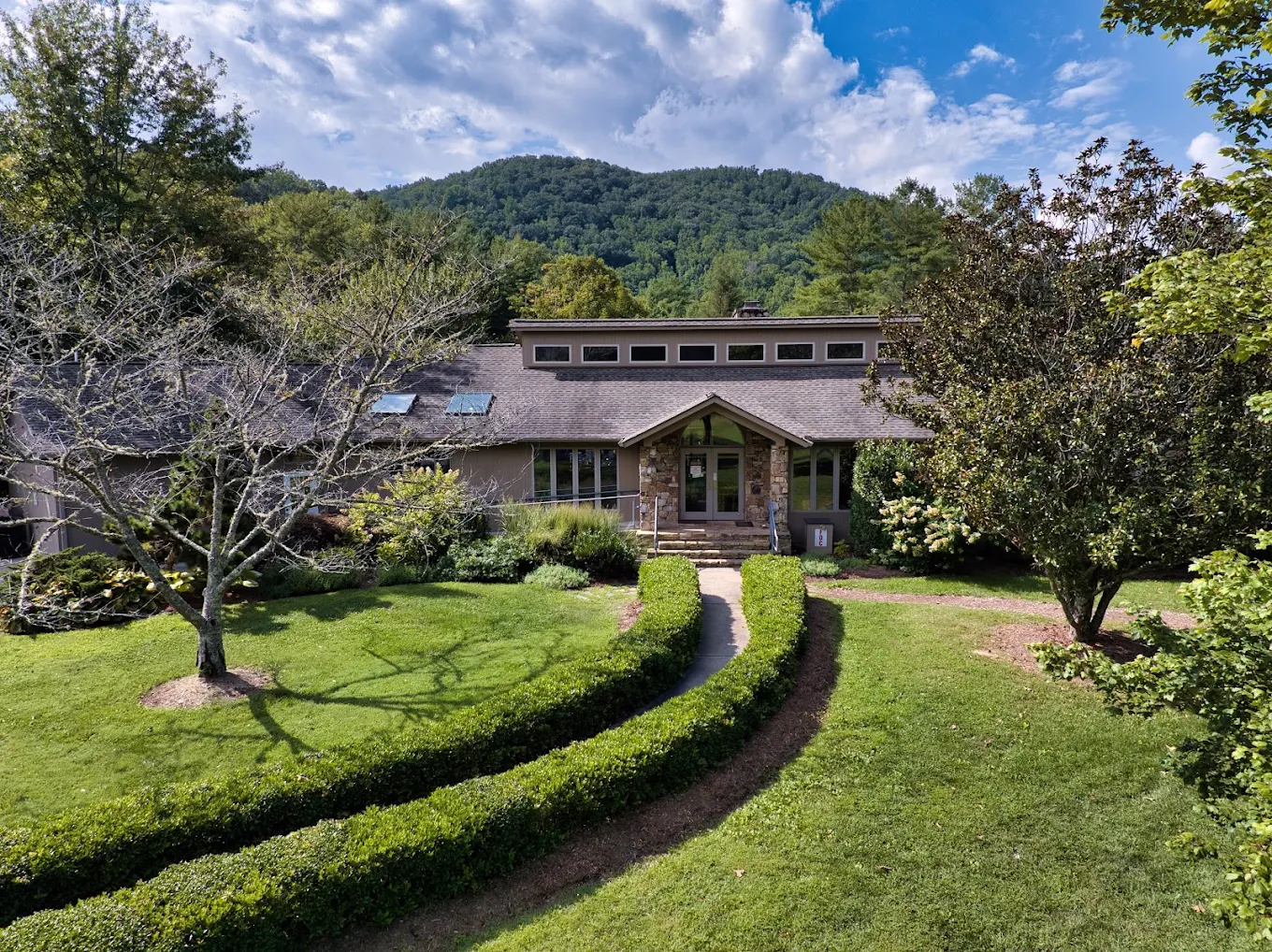 Recovery residence surrounded by landscaped grounds and wooded mountains