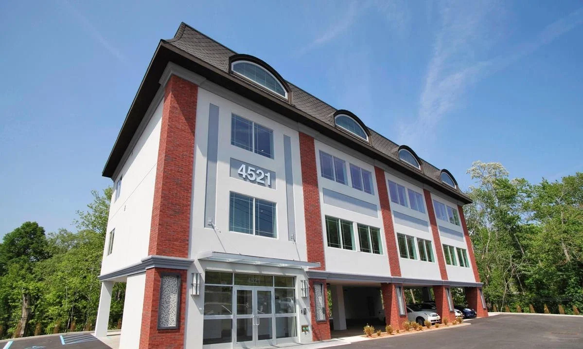 Modern three-story building with glass entry doors