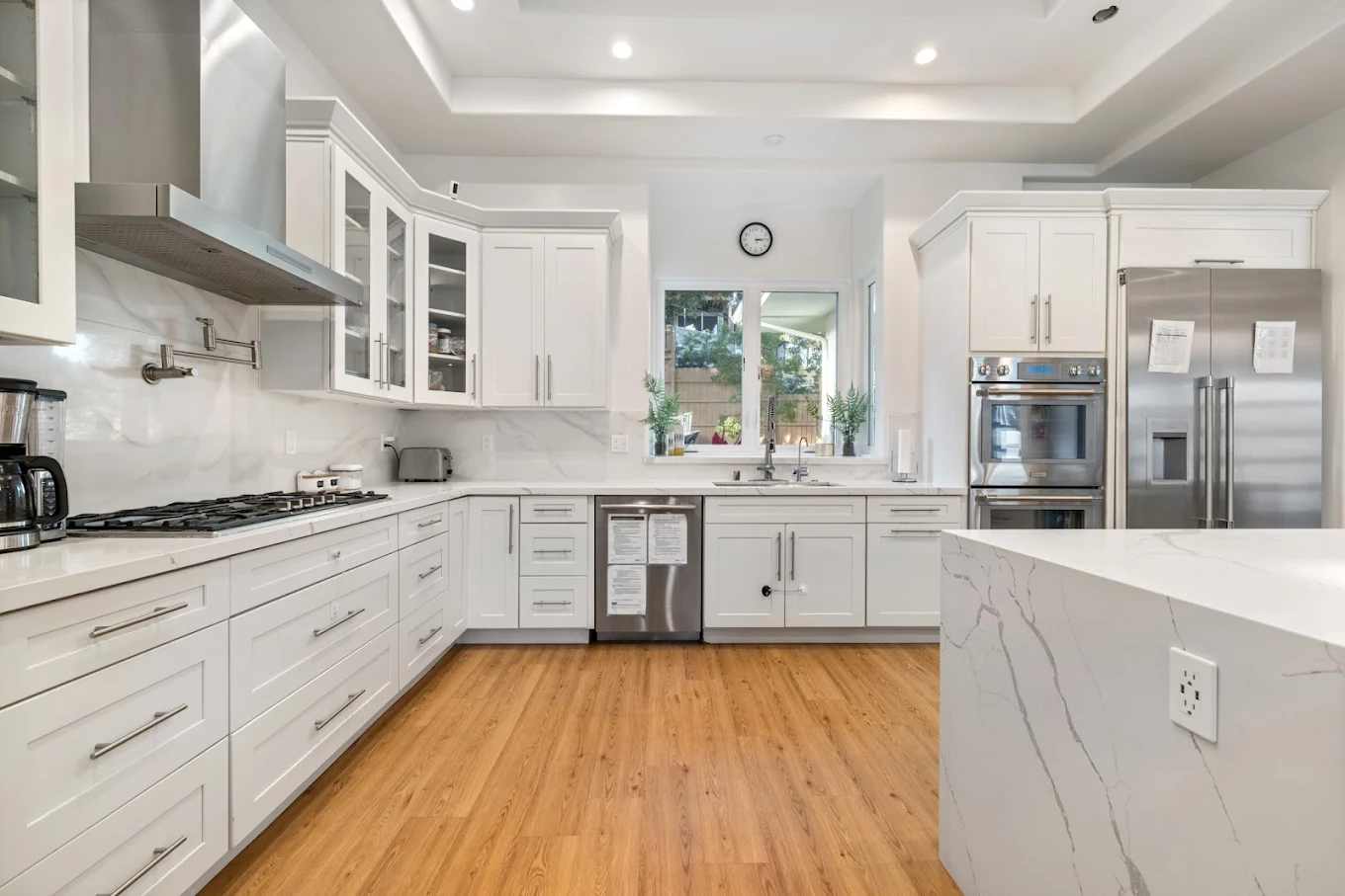 Full kitchen with white cabinets and stainless appliances