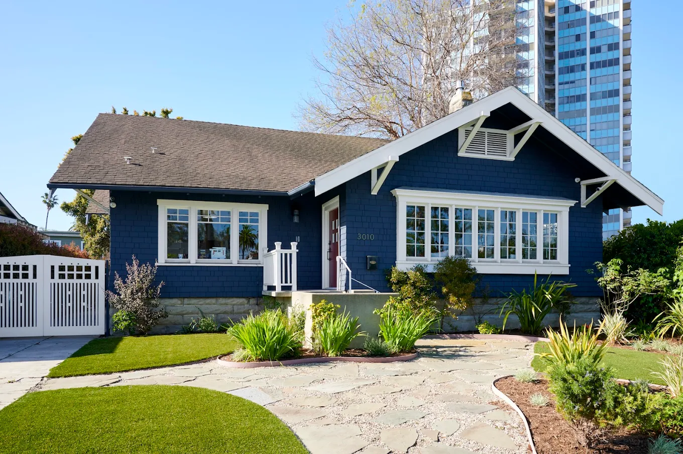 Blue exterior of facility surrounded by trees and lawn