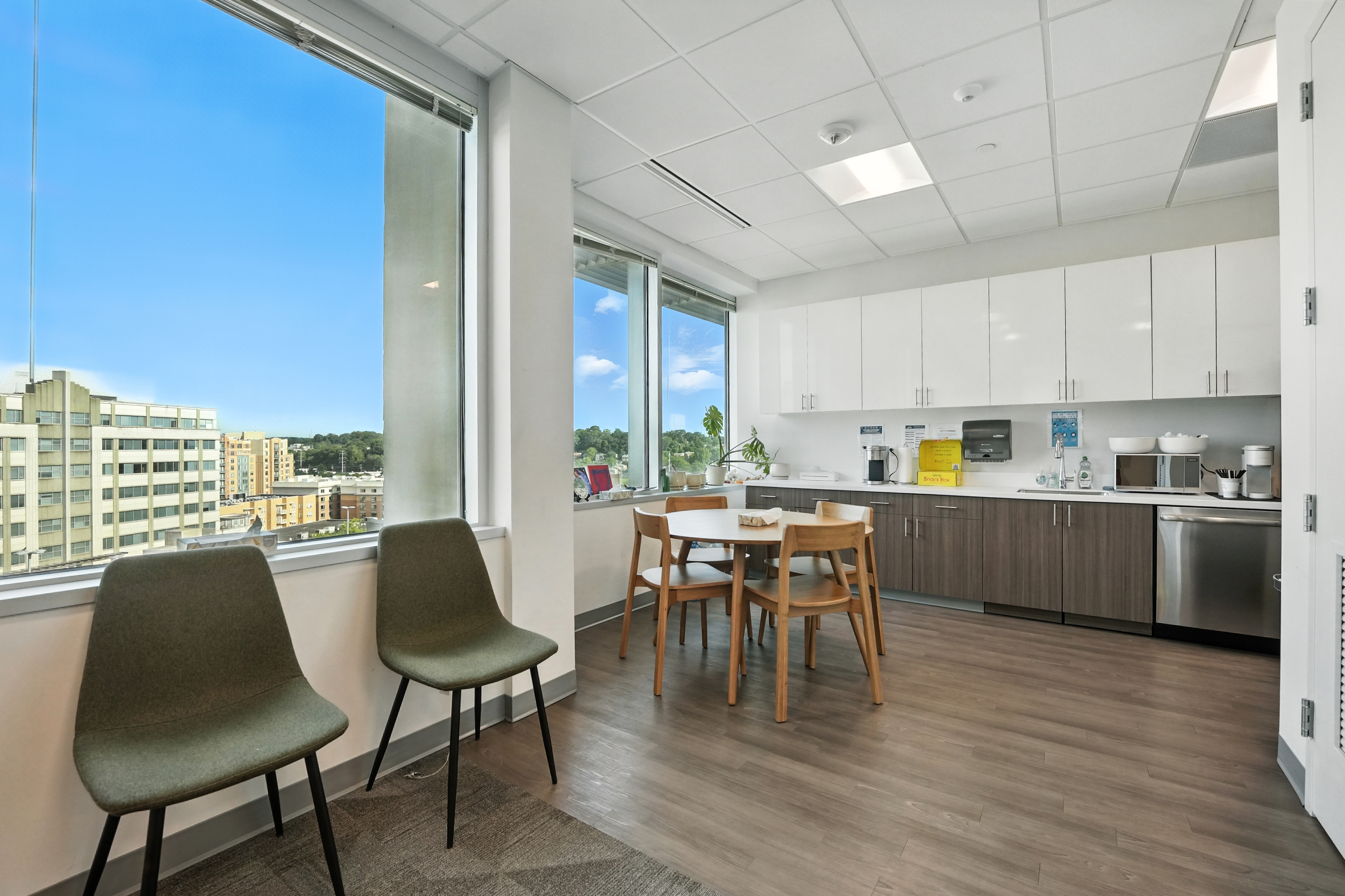 Bright office kitchen with dining table and city views