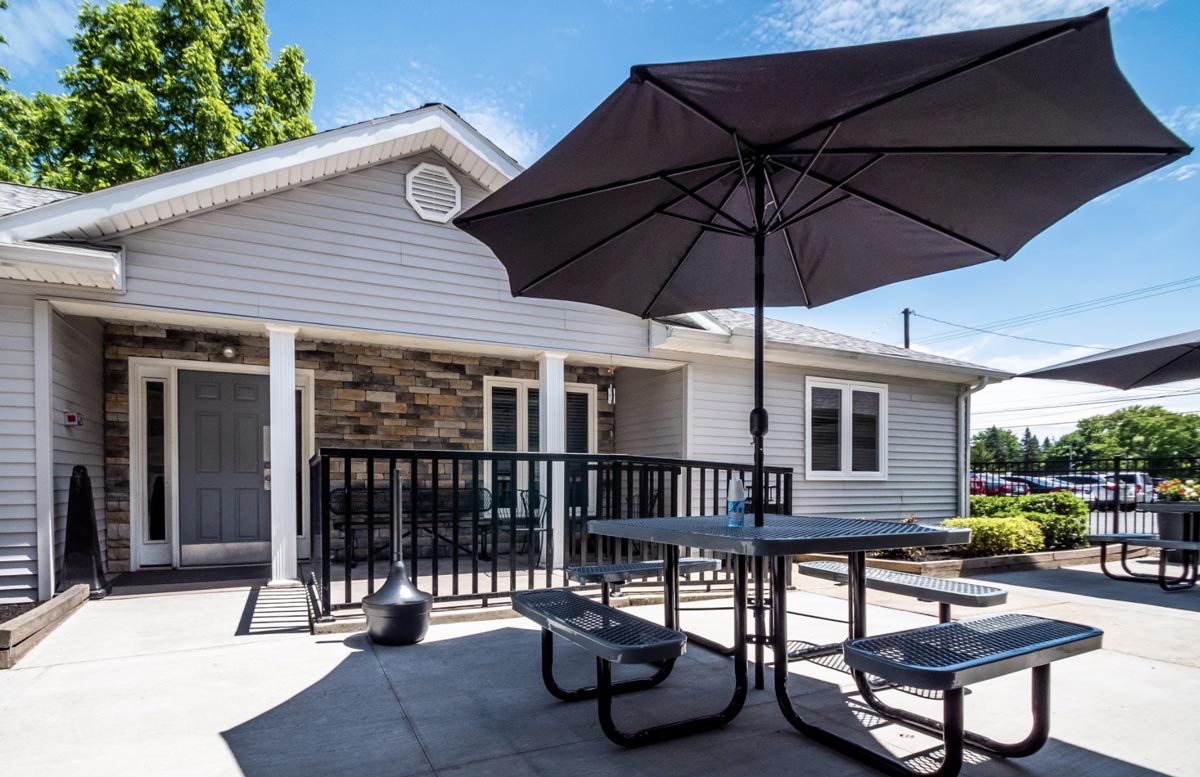 Outdoor seating with umbrellas near building entrance
