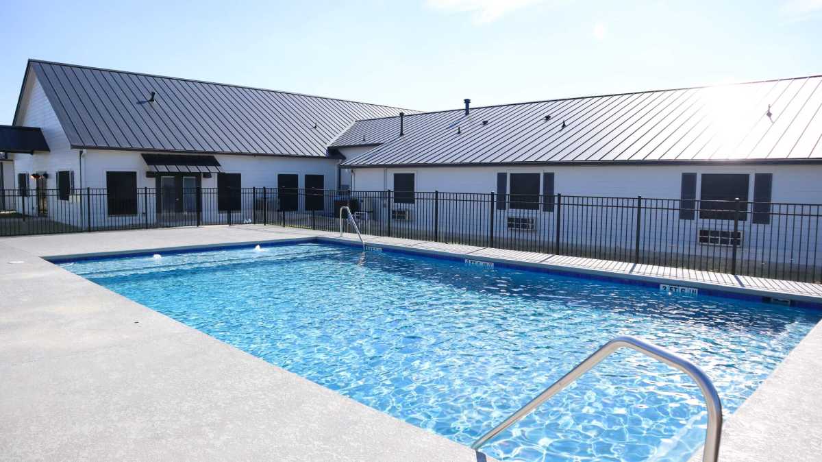 Outdoor swimming pool with surrounding patio and fencing