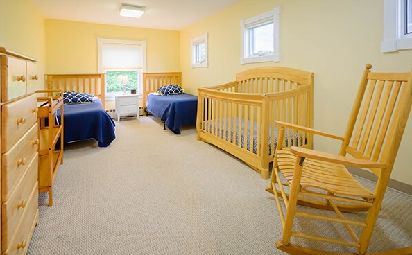 Cozy bedroom with two twin beds and a baby crib