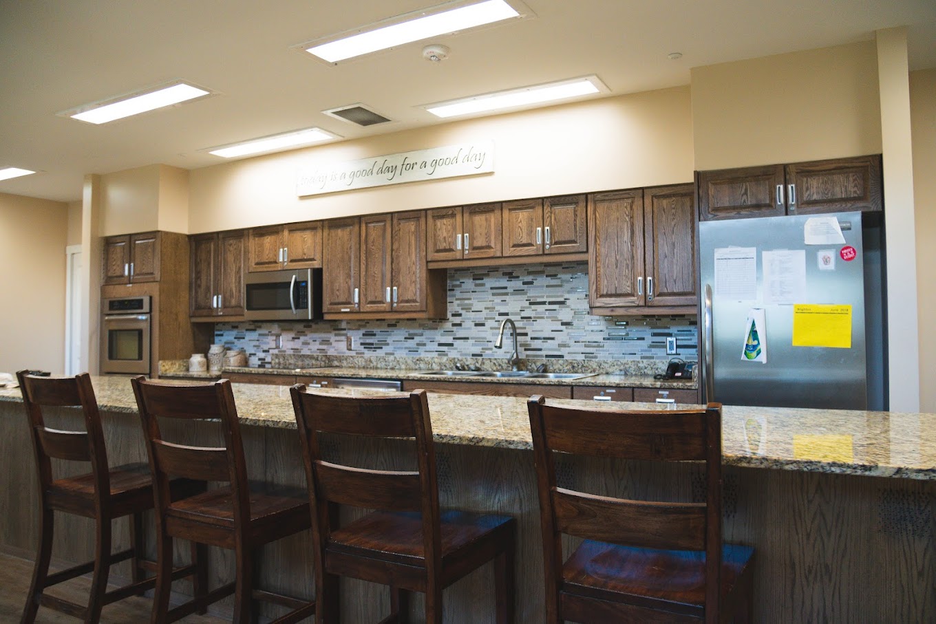 Kitchen with wood cabinets, granite counters, and bar seating