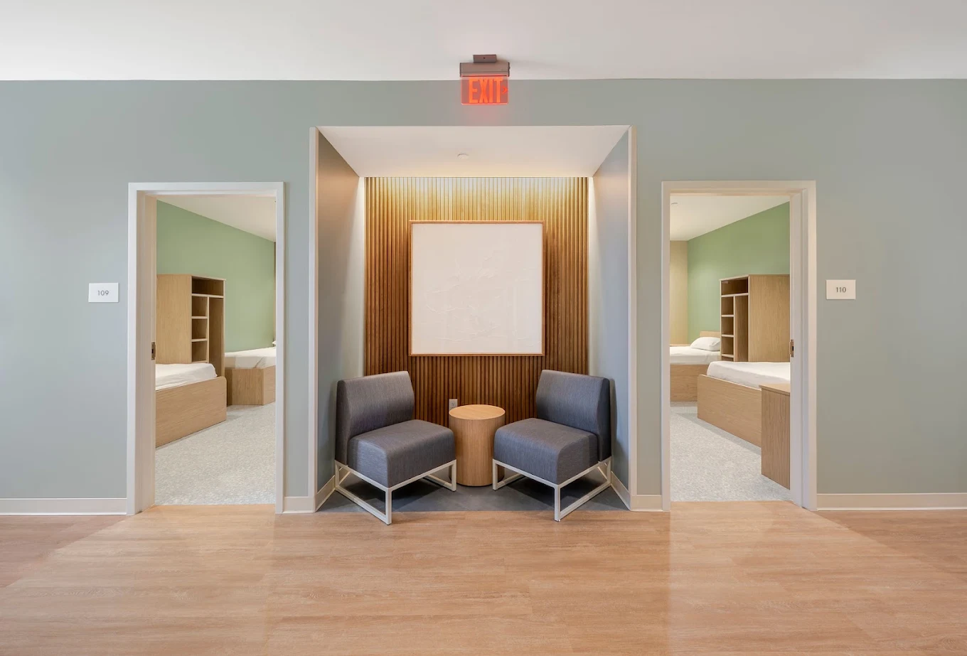 esidential hallway seating area between two open bedroom doorways