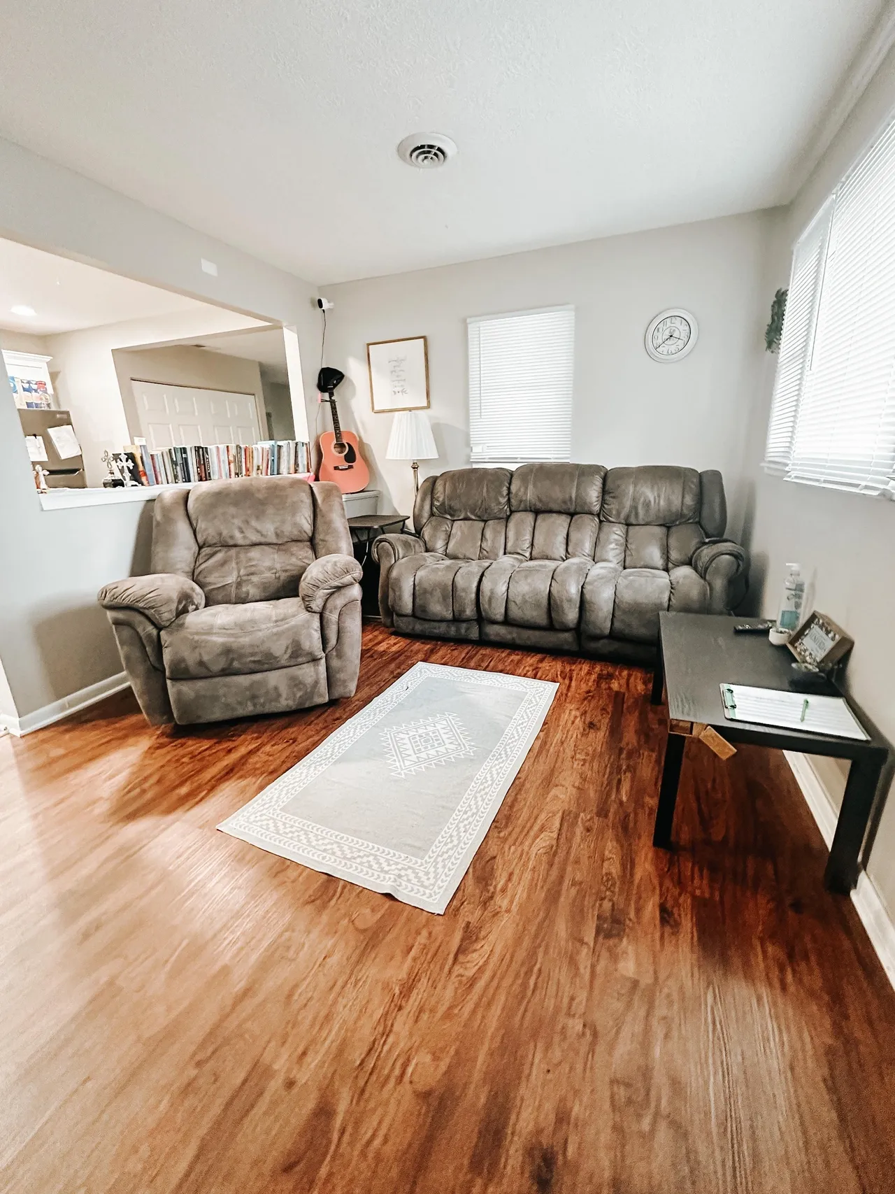 Cozy living room with recliner chairs, couch, and hardwood floors