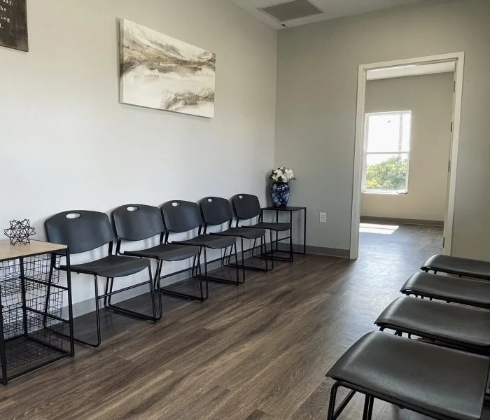 Simple waiting area with rows of black chairs and decor