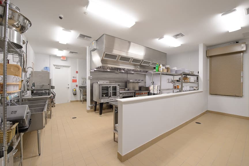 Professional kitchen with stove and prep counters