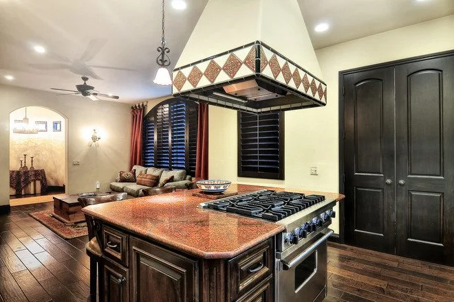 Kitchen with large island, stove, and open lounge area