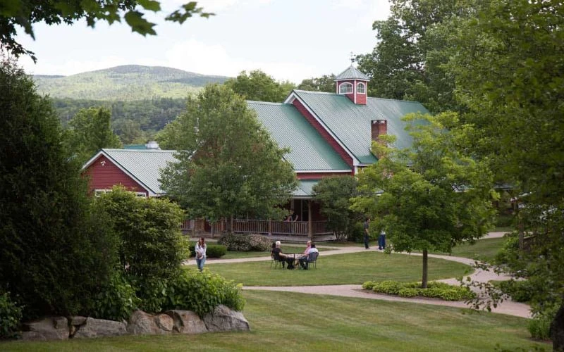 Red barn-style building with people on lawn