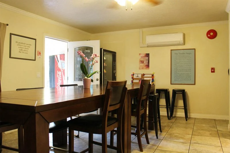 Warm dining room with tall wooden table and seating.