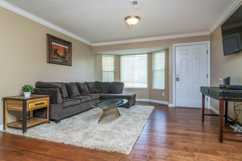 Cozy living room with sofa, rug, and large windows