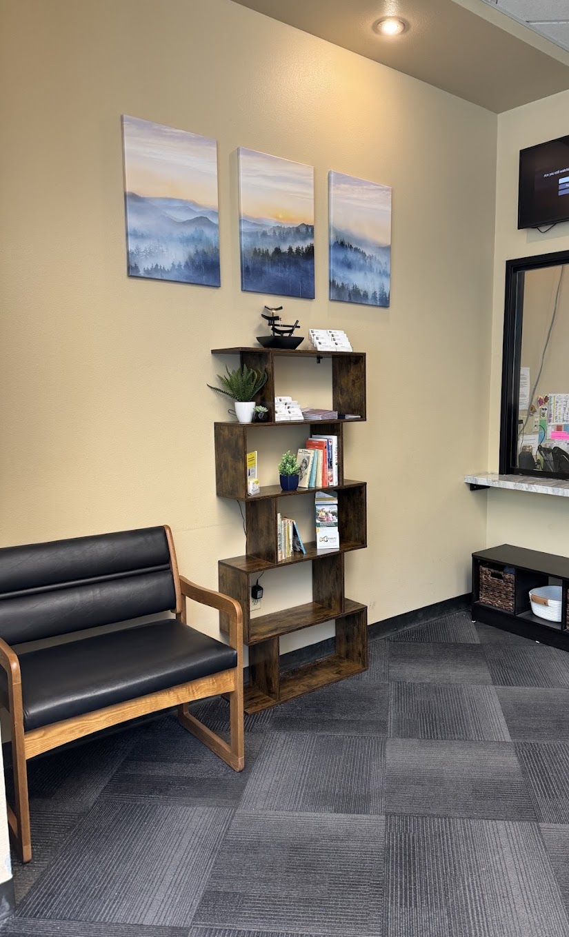 Reception area with black bench, bookshelf, and wall art