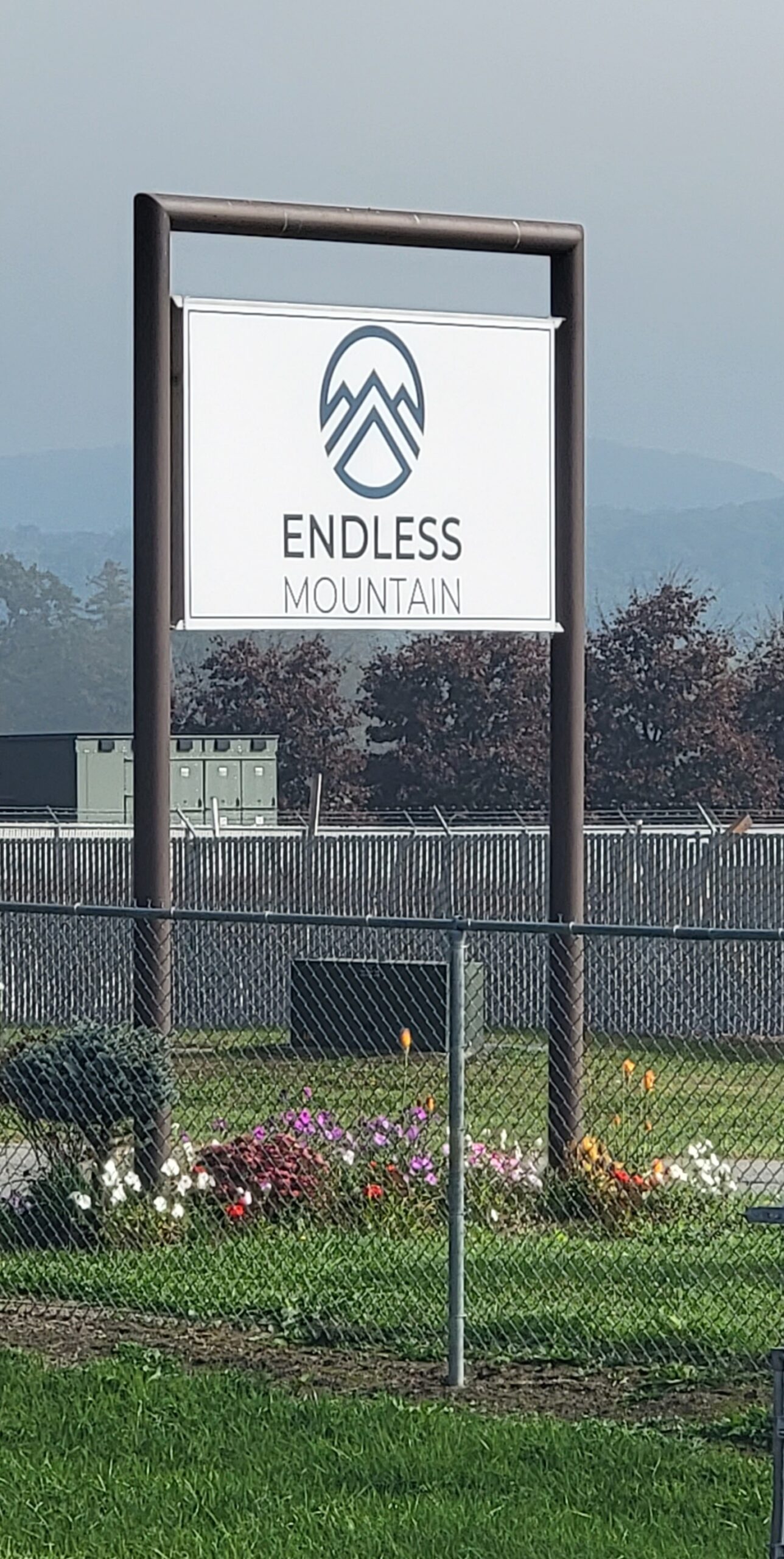 Endless Mountain sign with flowers and mountain backdrop