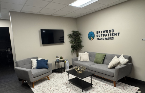 Comfortable waiting area with sofas, chairs, and TV