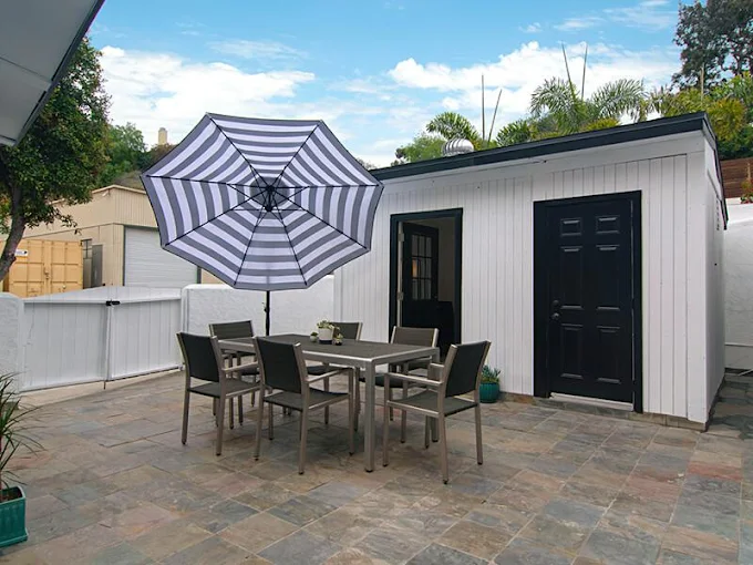 Outdoor patio with dining table and striped umbrella