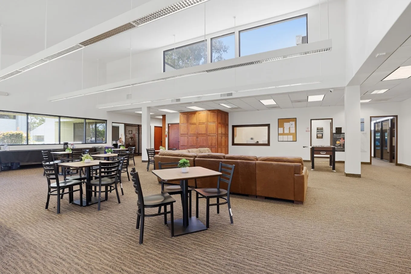 Open lounge and dining area with tables and leather seating