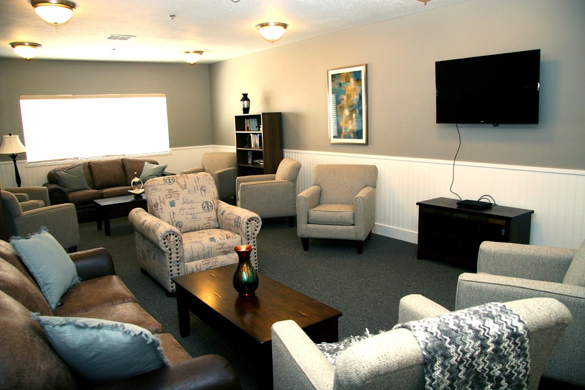 Group seating area with flat screen TV and bookshelves.