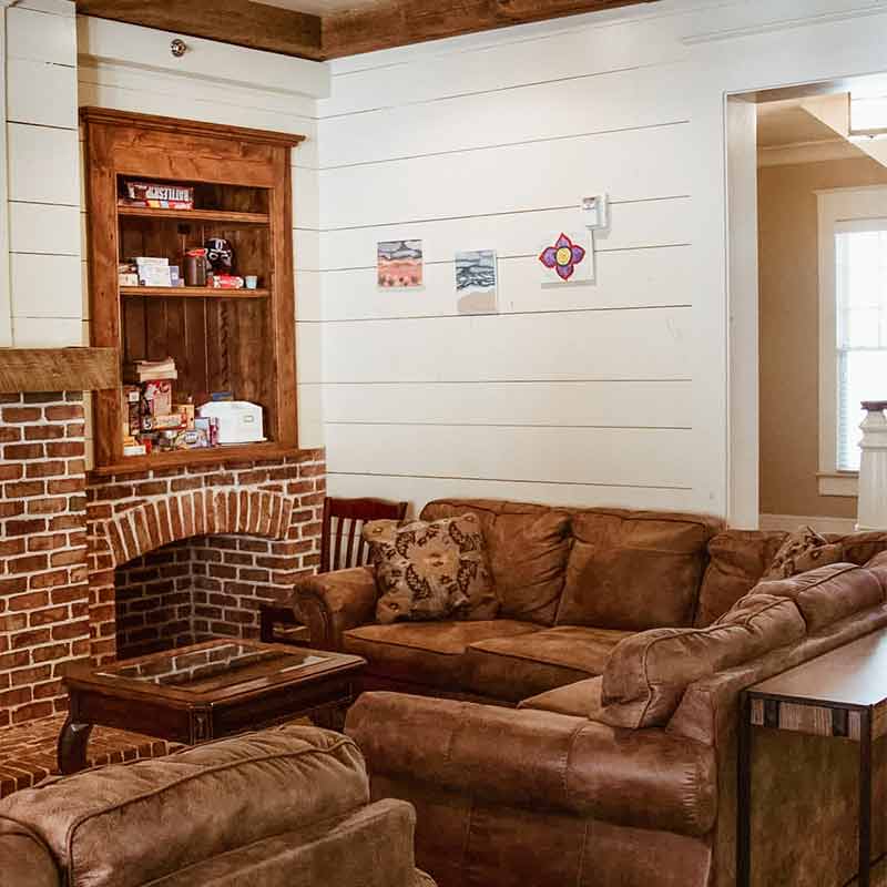 Cozy lounge area with couch seating and brick fireplace