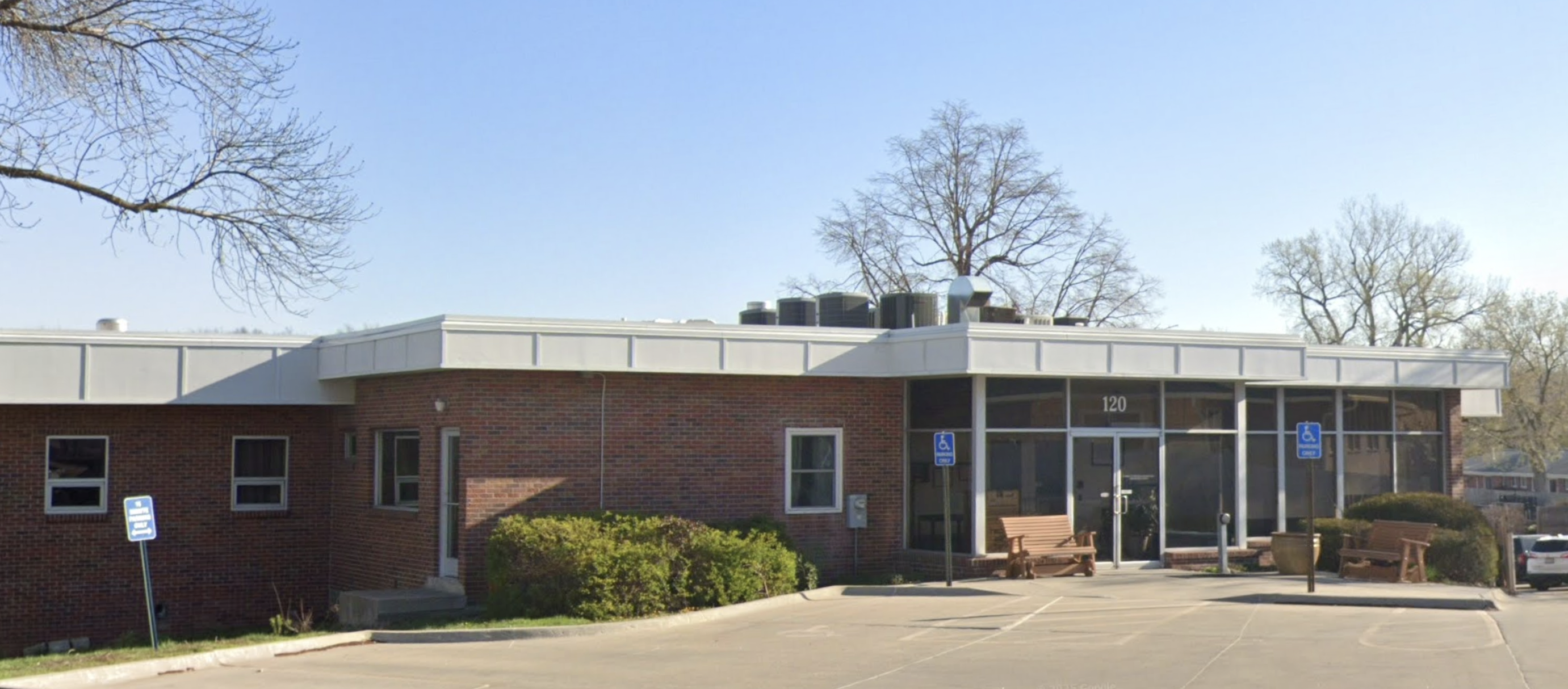 Brick building entrance with benches and accessible parking