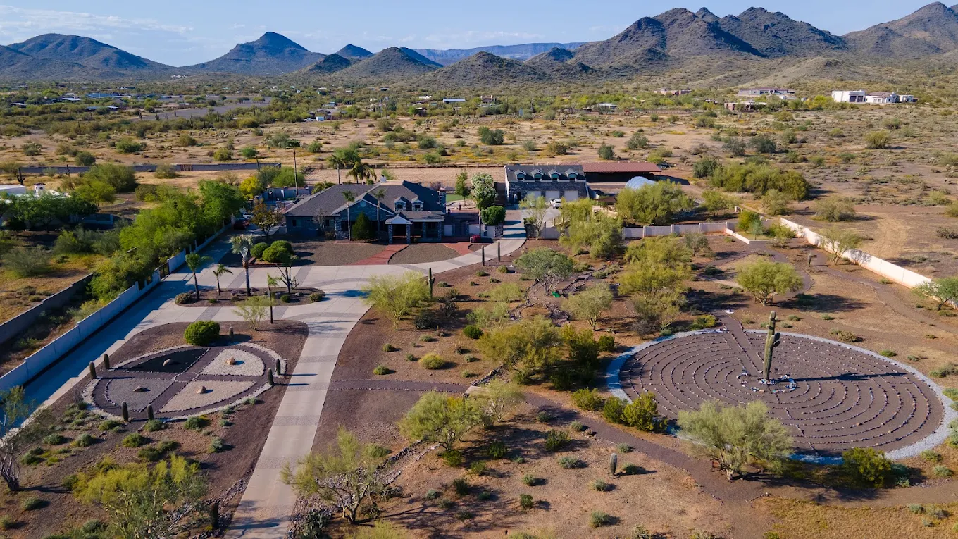 Aerial view of desert property with labyrinths and mountains