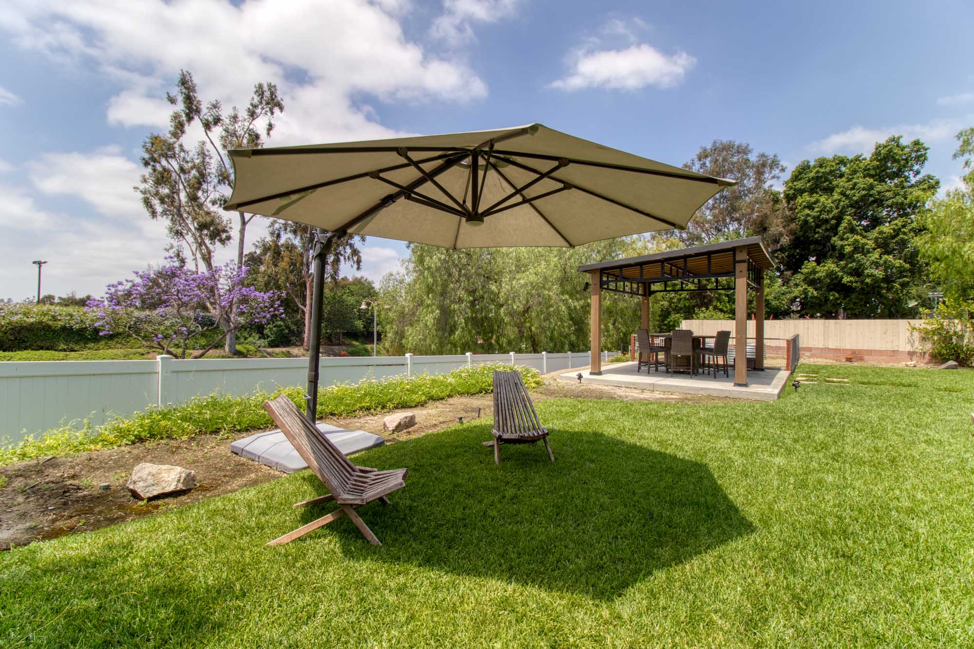 Shaded patio with table and chairs surrounded by greenery