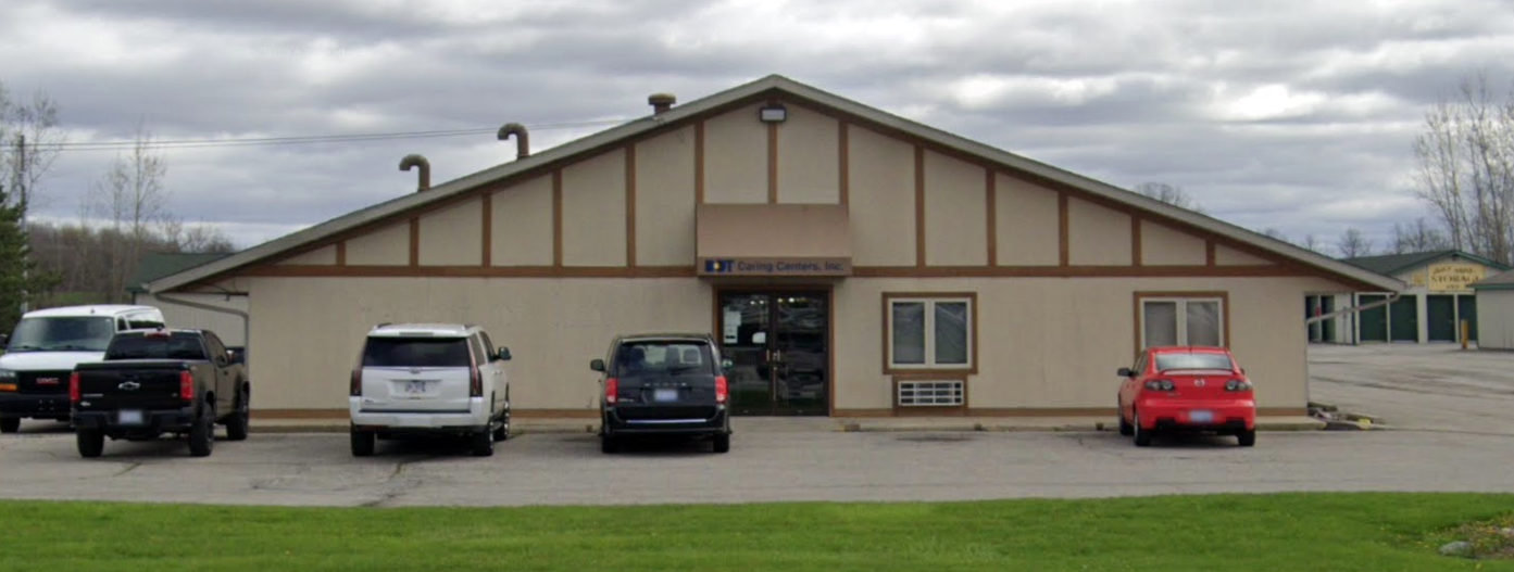 Front entrance with parked cars and signage