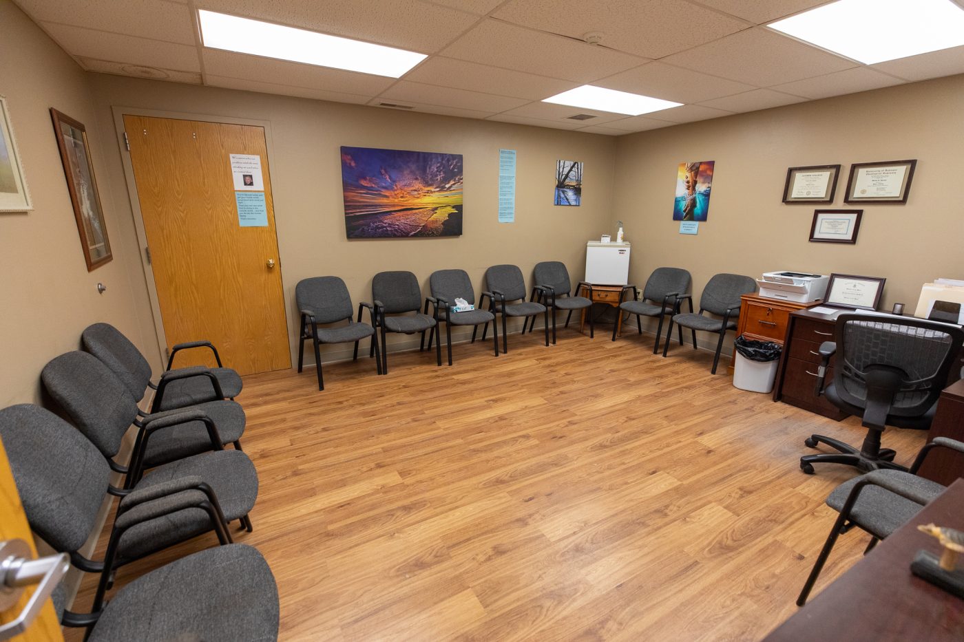 Waiting and intake room with chairs, desk, and framed certificates at addiction treatment center