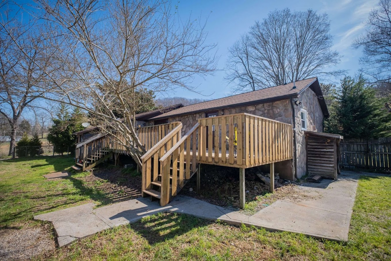 Small stone building with a wooden deck and stairs.