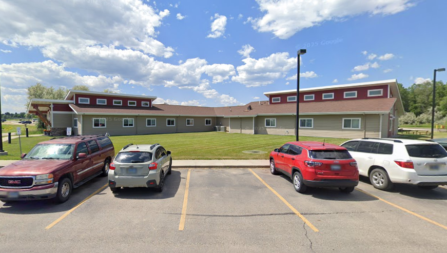 Parking lot facing long single-story Life House facility