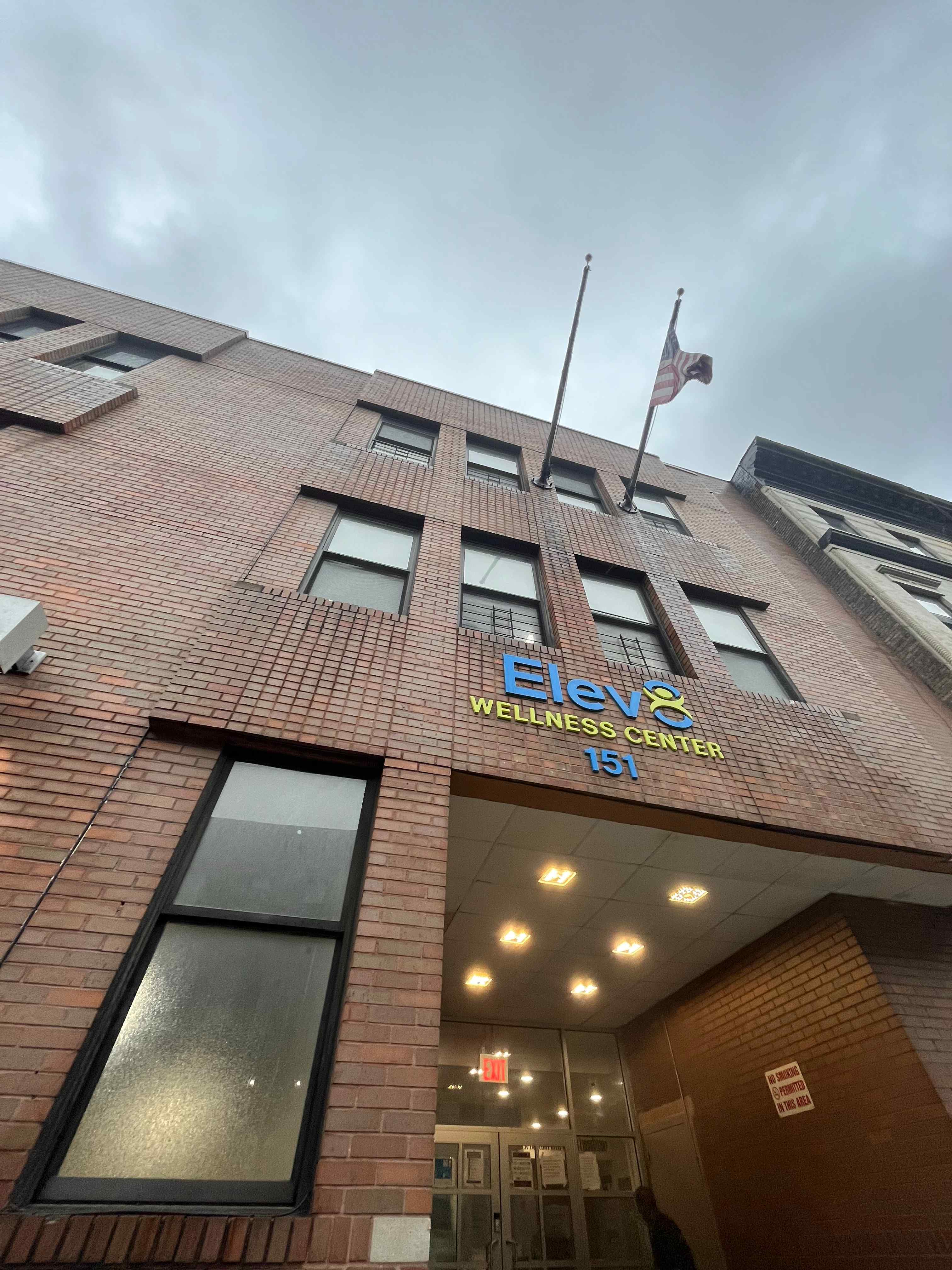 High-rise exterior with signage and street-level entry.