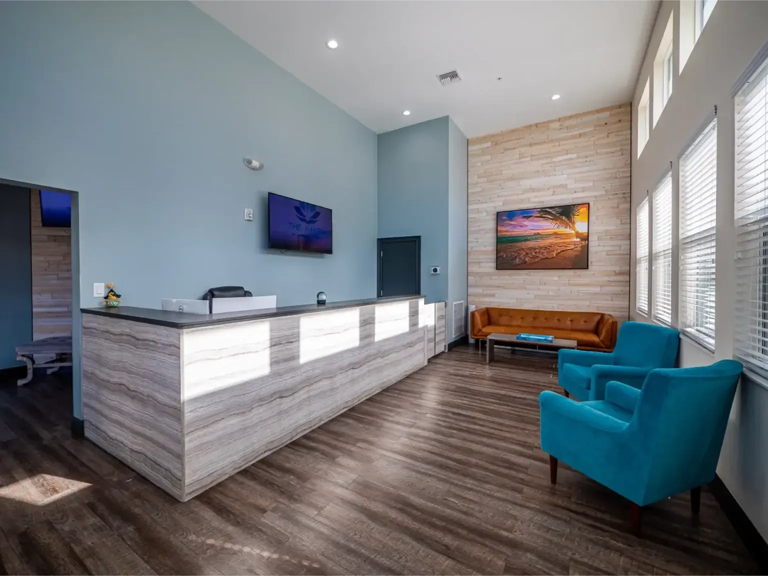 Modern lobby with seating, wood floors, and reception desk.