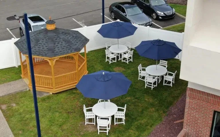 Wooden gazebo and patio tables with blue umbrellas