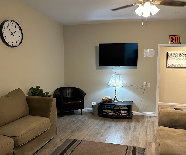 Lounge with tan sofa, coffee table, and wall-mounted TV