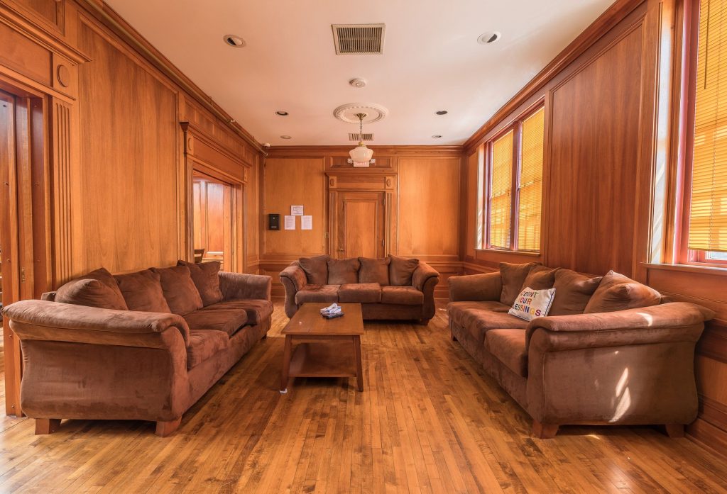 Warm lounge with brown couches and wood-paneled walls