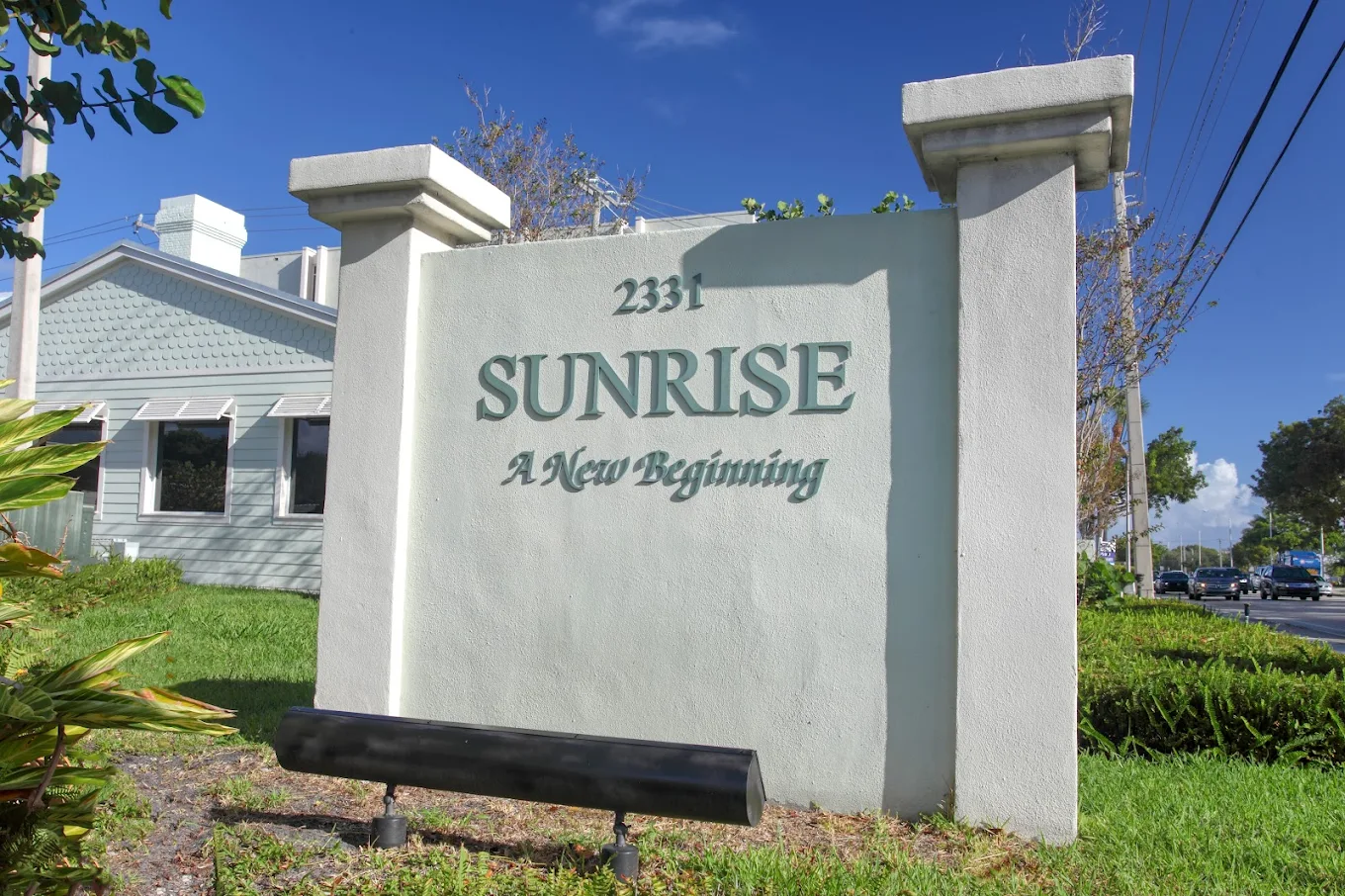 Entrance sign for Sunrise Detox facility on a sunny street