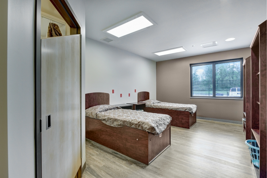 Two-bed rehab room with wood furnishings and large window