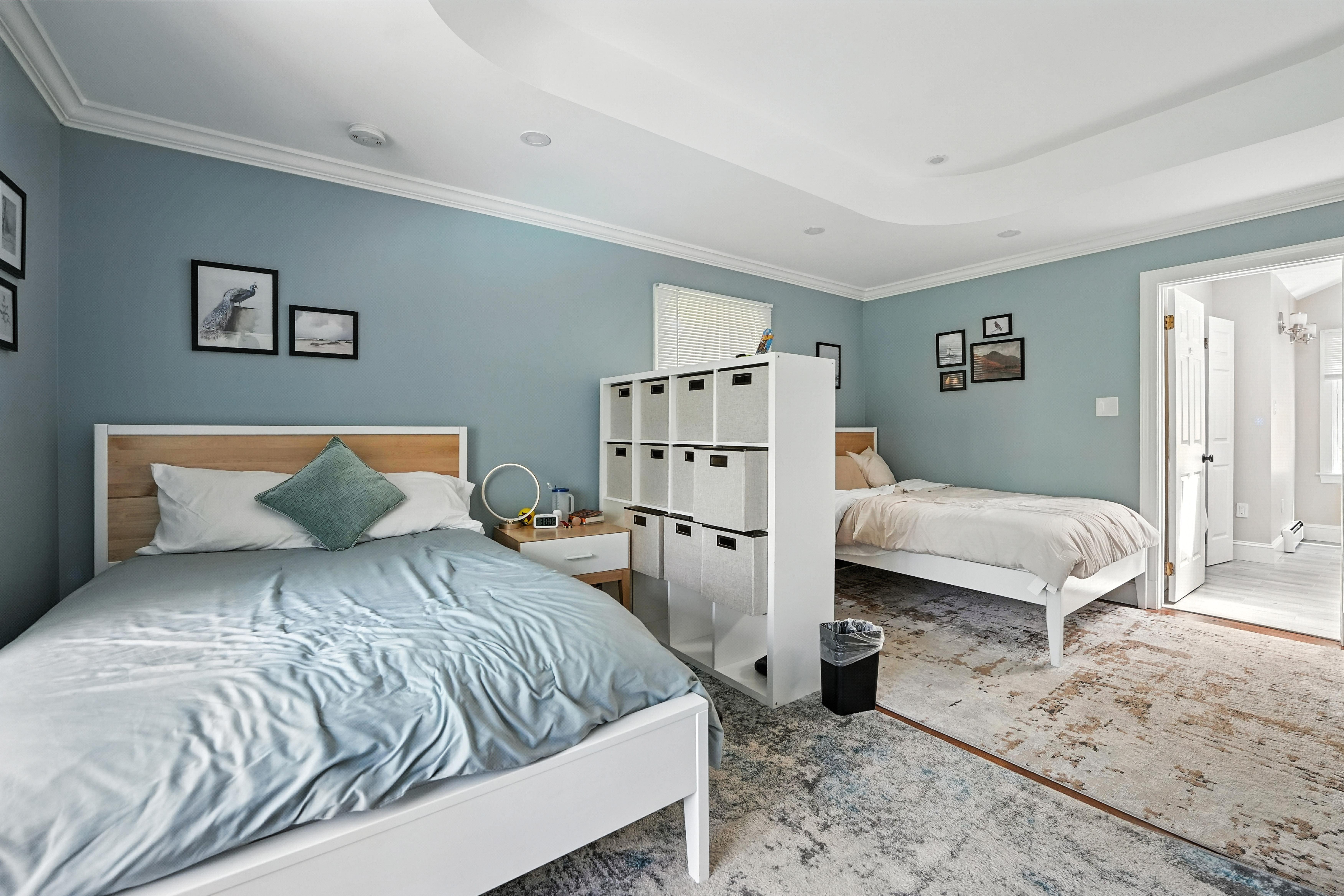 Shared bedroom with two beds and partition storage unit