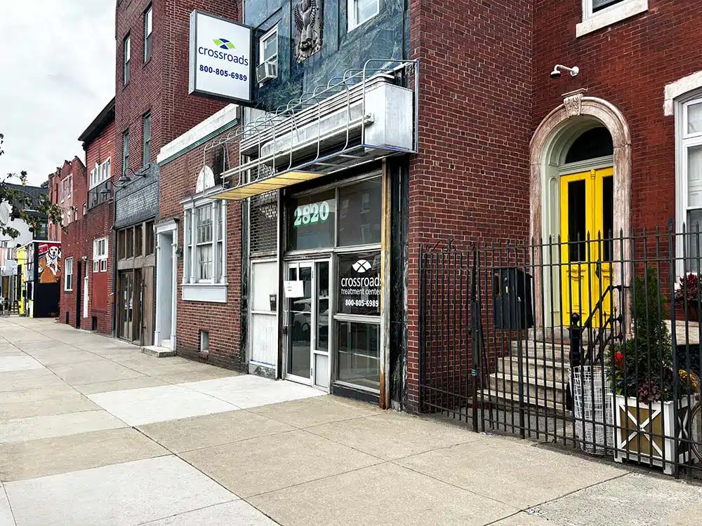 Brick building exterior with Crossroads sign on city street