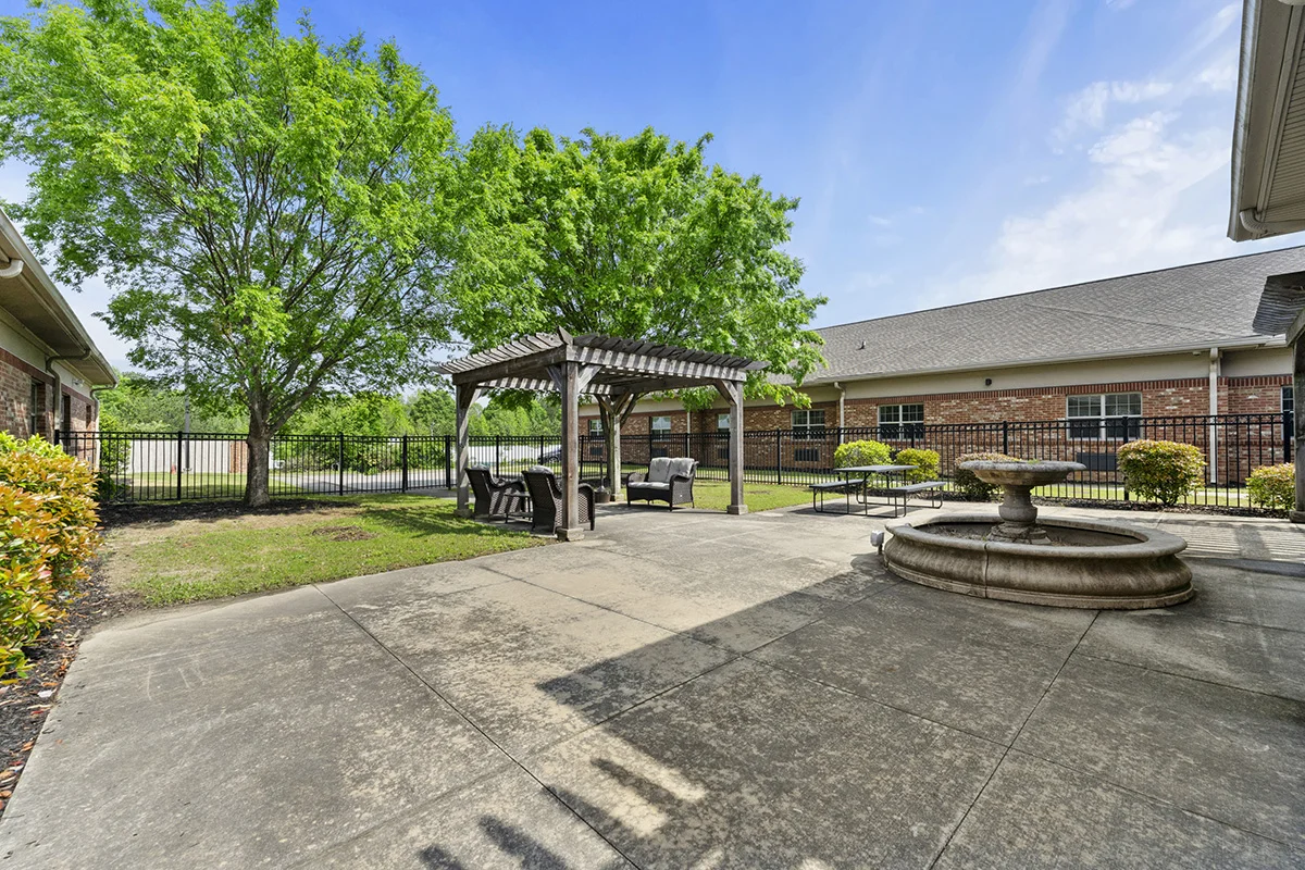 Outdoor courtyard with pergola seating, fountain, and landscaped patio for relaxation and recreation