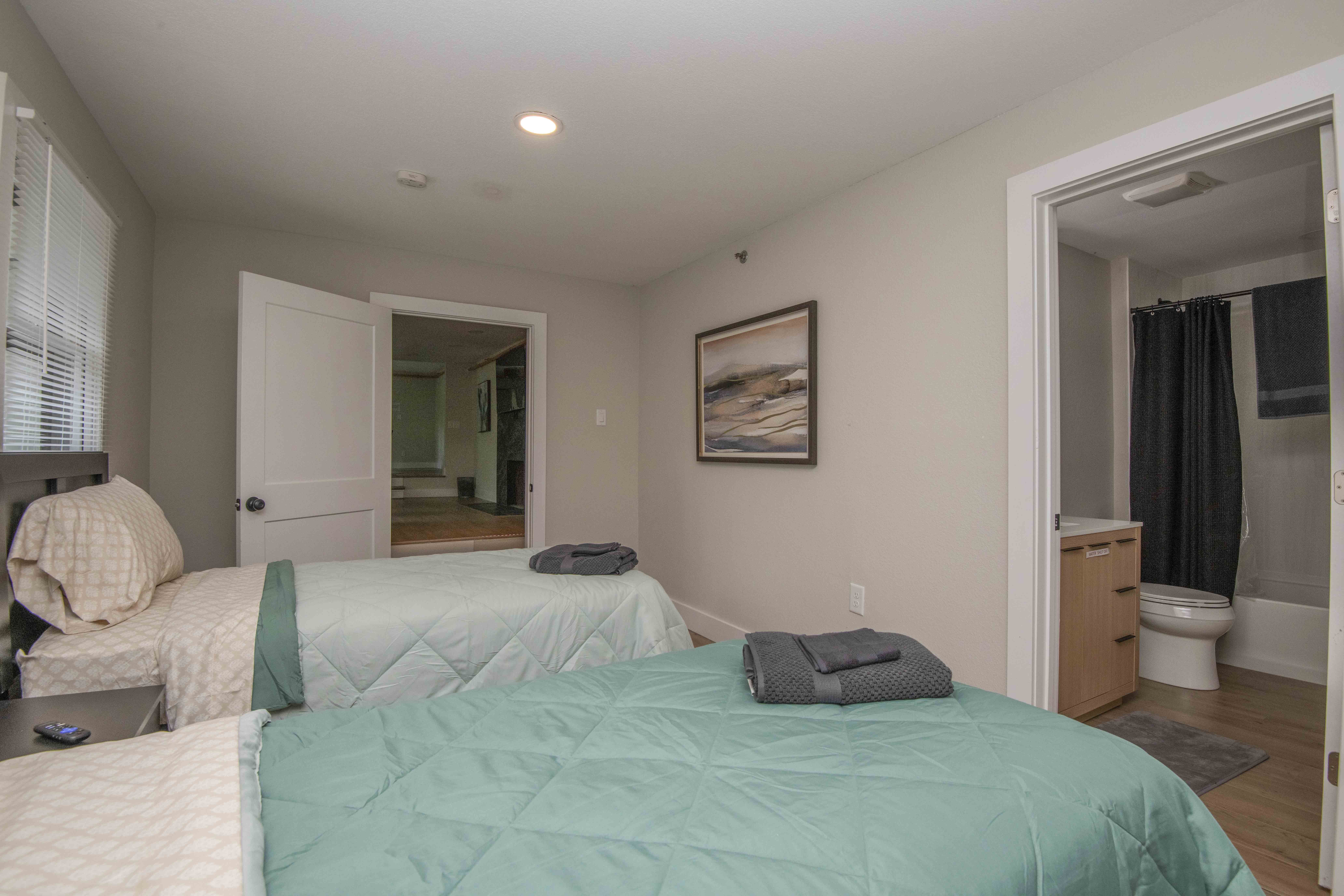 Two twin beds with neutral bedding and private bathroom
