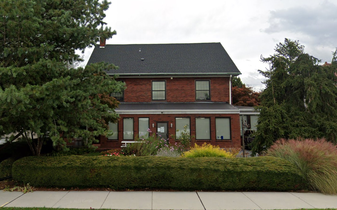 Brick building exterior of Gaudenzia Concept 90 with trees and shrubs