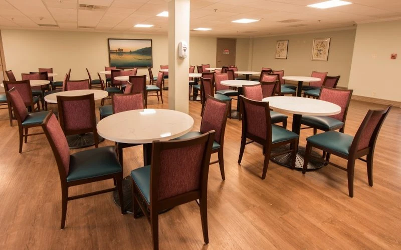 Round tables with cushioned chairs in open dining area