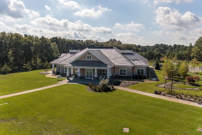 Rehab center building with lawn and trees under a blue sky