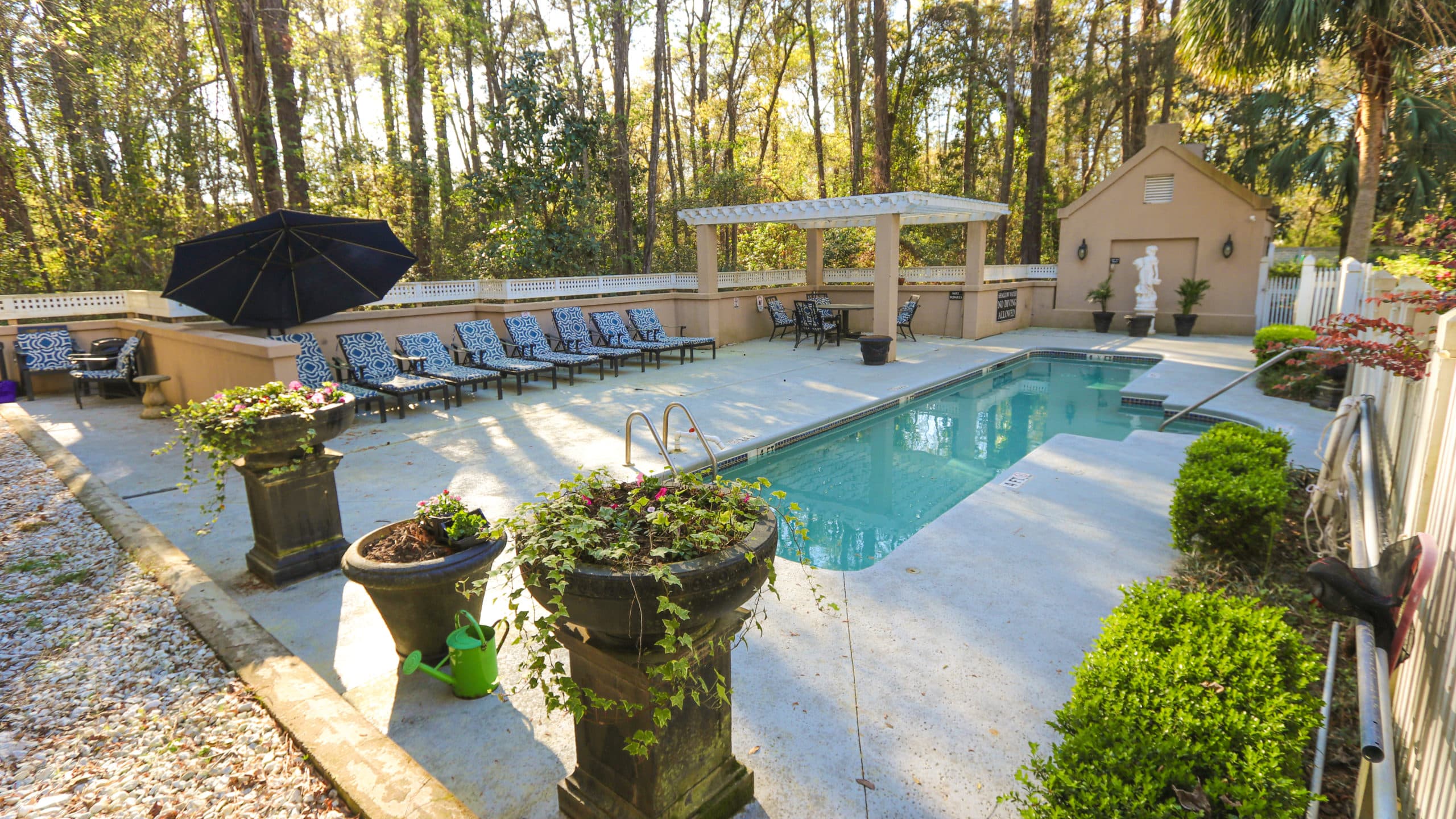 Pool area with lounge chairs and shaded patio