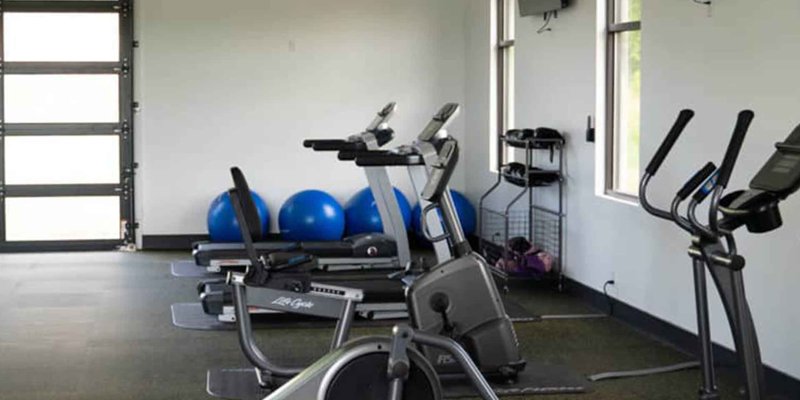 Bright, modern gym equipped with cardio machines and exercise balls, providing a motivating space for fitness and wellness activities.