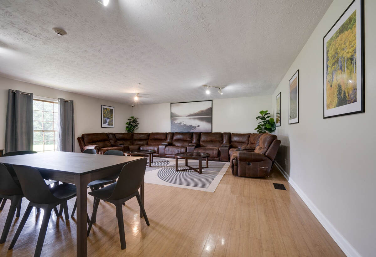 Lounge area with a large brown sectional sofa, dining table, and decor.