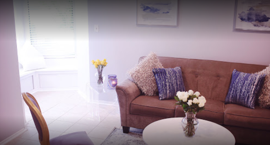 Sofa with pillows, flowers, and window seat in lounge